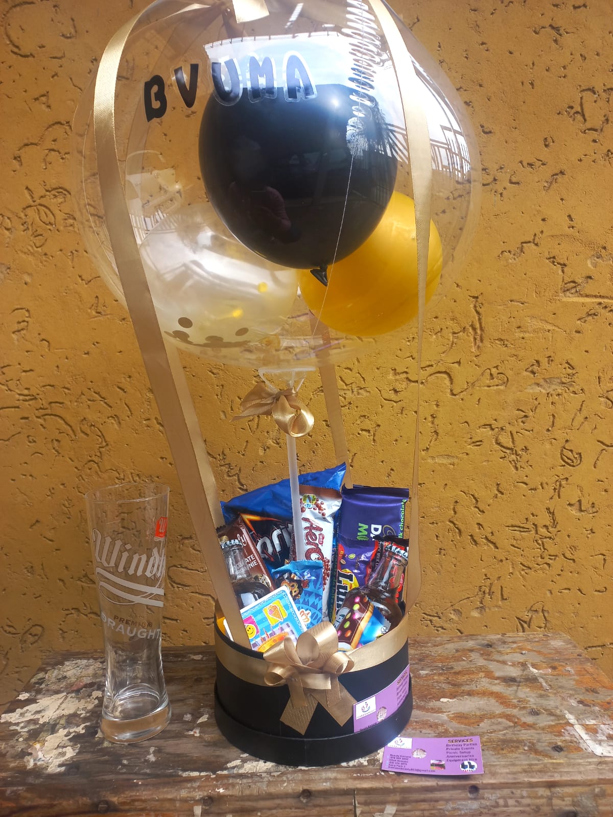 Personalised black and gold snack hamper with balloons